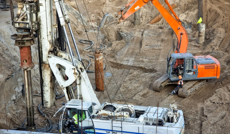 Closeup of heavy excavators and construction machines working on building site.